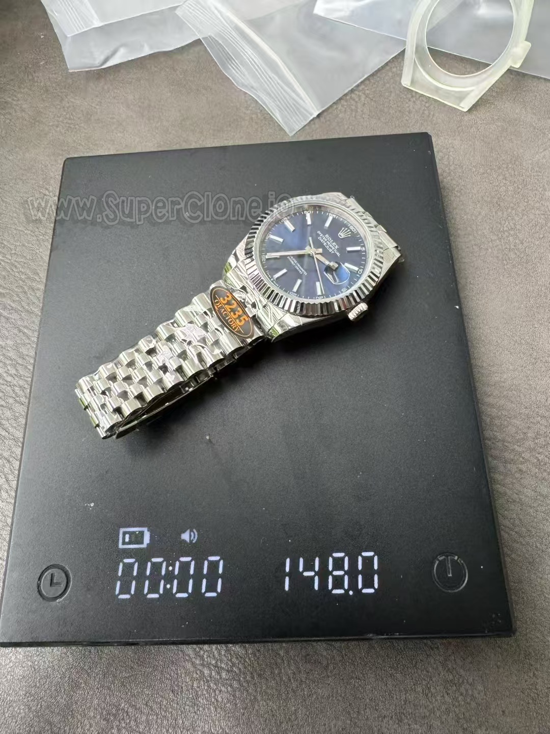 Digital scale showing Q Factory Datejust weight at 148 grams